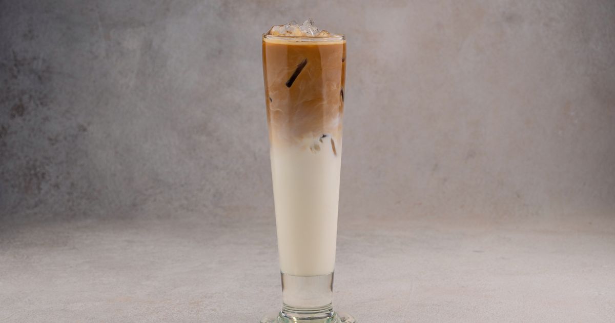 A tall glass of iced coffee with milk