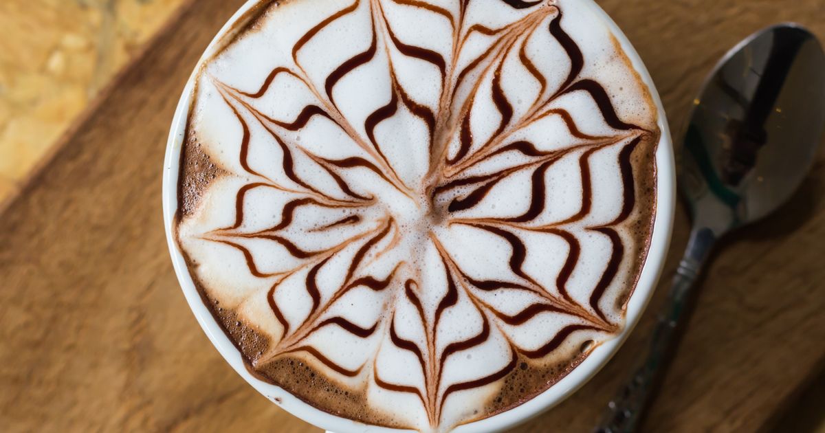 A coffee with a chocolate pattern on its milk foam