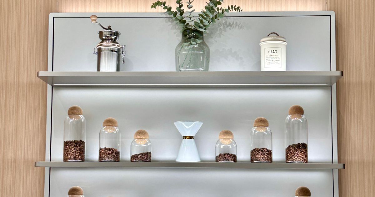 Glass jars of roasted coffee beans on a shelf